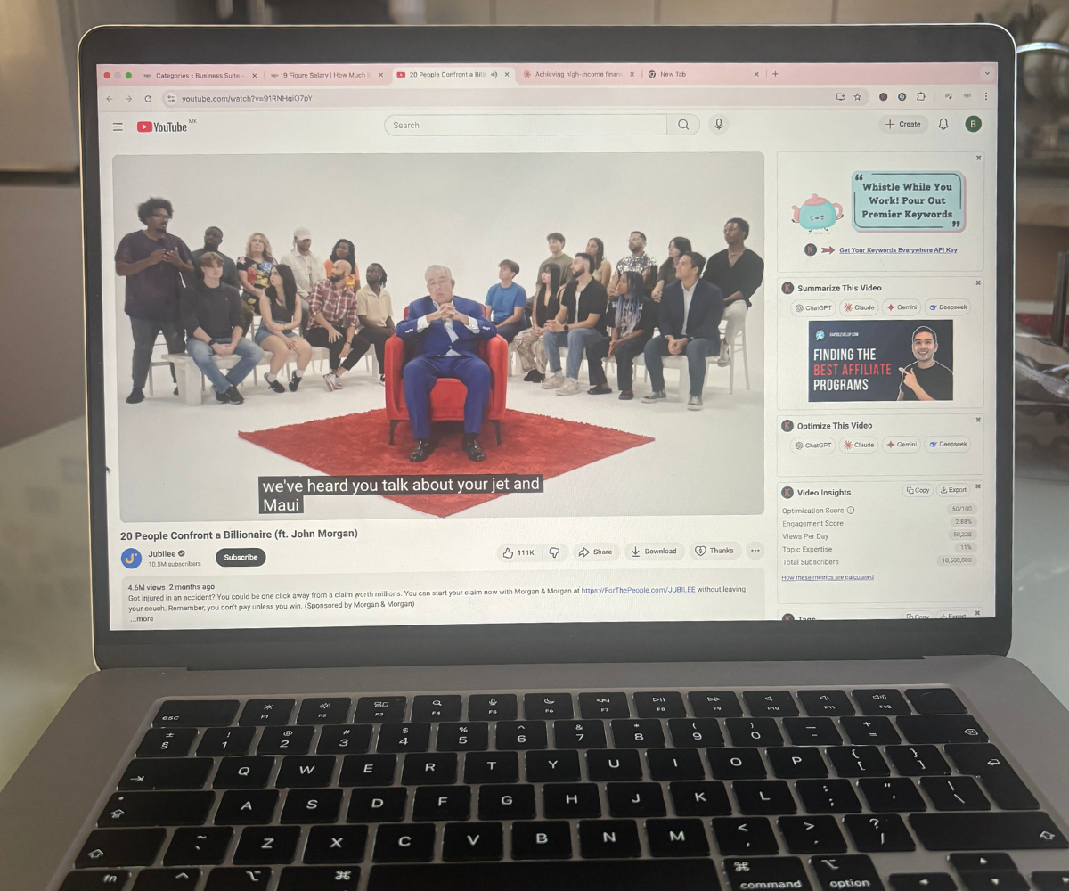 aptop displaying YouTube video titled '20 People Confront a Billionaire (ft. John Morgan)' where people are seated in chairs confronting a man in blue suit sitting in red chair on red carpet